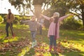 Image of happy multi generation caucasian family having fun with leaves in autumn garden Royalty Free Stock Photo