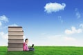 Happy schoolgirl sitting near a pile of books Royalty Free Stock Photo