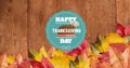 Image of happy thanksgiving day text over wooden background with autumn leaves Royalty Free Stock Photo