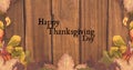 Image of happy thanksgiving day text over wooden background with autumn leaves Royalty Free Stock Photo