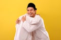 Image of happy two Young Asian Muslim men hugging each other during Eid Mubarak celebration on 1441 H