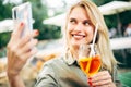 Image of happy woman with cocktail, photographing herself on street. Royalty Free Stock Photo