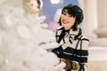 Image of happy woman near white artificial Christmas tree on walk at street Royalty Free Stock Photo