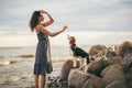 Image of happy woman 20s hugging her dog while walking along the beach Royalty Free Stock Photo