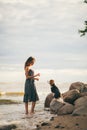 Image of happy woman 20s hugging her dog while walking along the beach Royalty Free Stock Photo