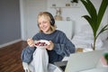 Image of happy woman sitting in a room, watching interesting tv show or movie on laptop, using screaming service Royalty Free Stock Photo
