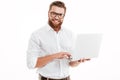 Happy young bearded man using laptop. Royalty Free Stock Photo