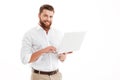 Happy young bearded man using laptop. Royalty Free Stock Photo