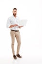 Happy young bearded man using laptop. Royalty Free Stock Photo