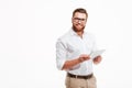 Happy young bearded man using tablet computer. Royalty Free Stock Photo