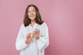 Image of a happy young beautiful woman posing isolated over pink wall background using mobile phone. The girl`s Royalty Free Stock Photo