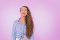 Image of a happy young excited lovely curly woman posing copy space isolated over purple wall background. A girl smiling