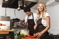 Happy young friends loving couple chefs on the kitchen cooking. Royalty Free Stock Photo