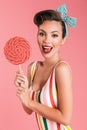 Happy young pin up woman holding candy lollipop. Royalty Free Stock Photo