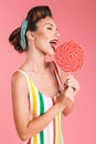 Happy young pin up woman holding candy lollipop. Royalty Free Stock Photo