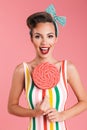 Happy young pin up woman holding candy lollipop. Royalty Free Stock Photo