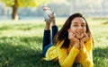 Image of happy young teenage girl smiling and relaxing outside in nature green park. Cheerful young beautiful woman lying outdoors Royalty Free Stock Photo