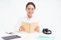 Image of hardworking student, asian woman in glasses studying, holding notebook, working on project, isolated over white