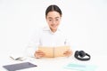 Image of hardworking student, asian woman in glasses studying, holding notebook, working on project, isolated over white