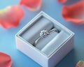 image has produced an image of a solitaire diamond ring in a white box, adorned with soft pink petals Royalty Free Stock Photo