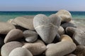 image of a heart-shaped sea stone which lies among other sea stones against the background of the sea Royalty Free Stock Photo