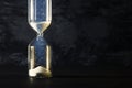 Image of hourglass as time passing concept over black background for business deadline. Glitter overlay. Royalty Free Stock Photo