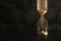 Image of hourglass as time passing concept over black background for business deadline. Glitter overlay. Royalty Free Stock Photo