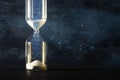 Image of hourglass as time passing concept over black background for business deadline. Glitter overlay. Royalty Free Stock Photo