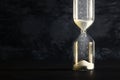 Image of hourglass as time passing concept over black background for business deadline. Glitter overlay. Royalty Free Stock Photo