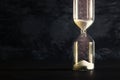 Image of hourglass as time passing concept over black background for business deadline. Glitter overlay. Royalty Free Stock Photo