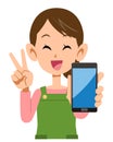 Housewife holding smartphone and showing V sign