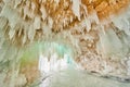 Ice cavern on frozen lake with ceiling covered in small icicles