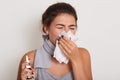 Image of ill allergic woman blowing running nose, having got flu or catch cold, sneezing in handkerchief, posing with closed eyes Royalty Free Stock Photo