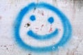 Image or illustration of a blue smile icon made using spray paint