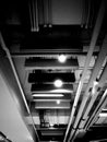 Monochrome indoor ceiling showing pipeline, lights, and electric lines Royalty Free Stock Photo