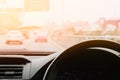 Image inside the car show steering wheel with car console on blurry traffic highway for insurance business.