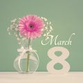 Image of International women day concept with beautiful flower in the vase on wooden table.