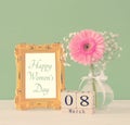 Image of International women day concept with beautiful flower in the vase on wooden table. Royalty Free Stock Photo