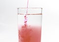 An image isolated pouring beverage or red water drink fresh or sirup cranberry mixed water in the glass clean on white background Royalty Free Stock Photo