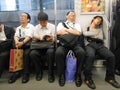 Image of Japanese men of different ages in the subway. White shirt, pants and black shoes.-- Inemuri : Sleepy in the subwa