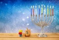 low key image of jewish holiday Hanukkah with menorah (traditional Candelabra) and wooden dreidels (spinning top) Royalty Free Stock Photo