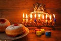 image of jewish holiday Hanukkah with menorah (traditional Candelabra), donuts and wooden dreidels (spinning top) Royalty Free Stock Photo