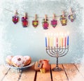 image of jewish holiday Hanukkah with menorah (traditional Candelabra), donuts and wooden dreidels (spinning top). retro filtered Royalty Free Stock Photo