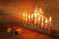 low key image of jewish holiday Hanukkah with menorah (traditional Candelabra) and wooden dreidels (spinning top). glitter overlay Royalty Free Stock Photo