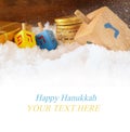 image of jewish holiday Hanukkah with wooden colorful dreidels (spinning top) and chocolate traditional coins over december snow.