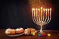 image of jewish holiday Hanukkah with menorah (traditional Candelabra), donuts and wooden dreidels (spinning top) Royalty Free Stock Photo