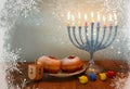 Image of jewish holiday Hanukkah with menorah (traditional Candelabra), donuts and wooden dreidels (spinning top). retro filtered Royalty Free Stock Photo