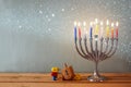 Image of jewish holiday Hanukkah with menorah (traditional Candelabra) and wooden dreidels (spinning top). Royalty Free Stock Photo