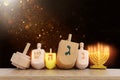 Image of jewish holiday Hanukkah with wooden dreidels collection (spinning top) over glitter background Royalty Free Stock Photo
