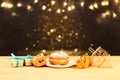 Image of jewish holiday Hanukkah with wooden dreidels & x28;spinning top& x29; and donut on the table. Royalty Free Stock Photo